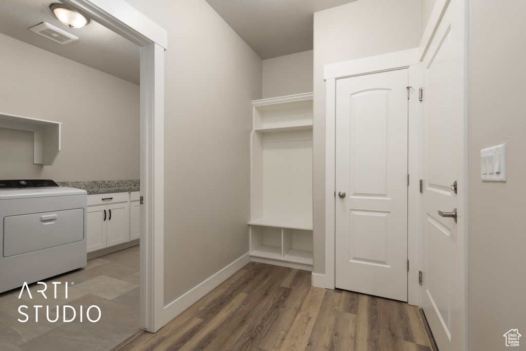 Mudroom featuring baseboards, washer / clothes dryer, light wood-type flooring, and visible vents