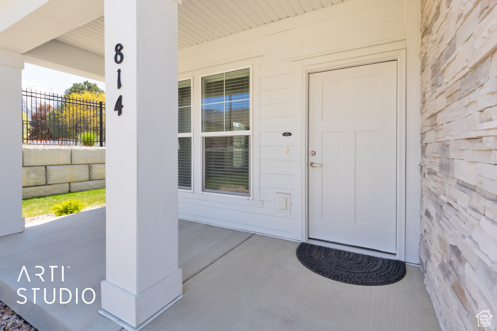 Property entrance with a porch and fence