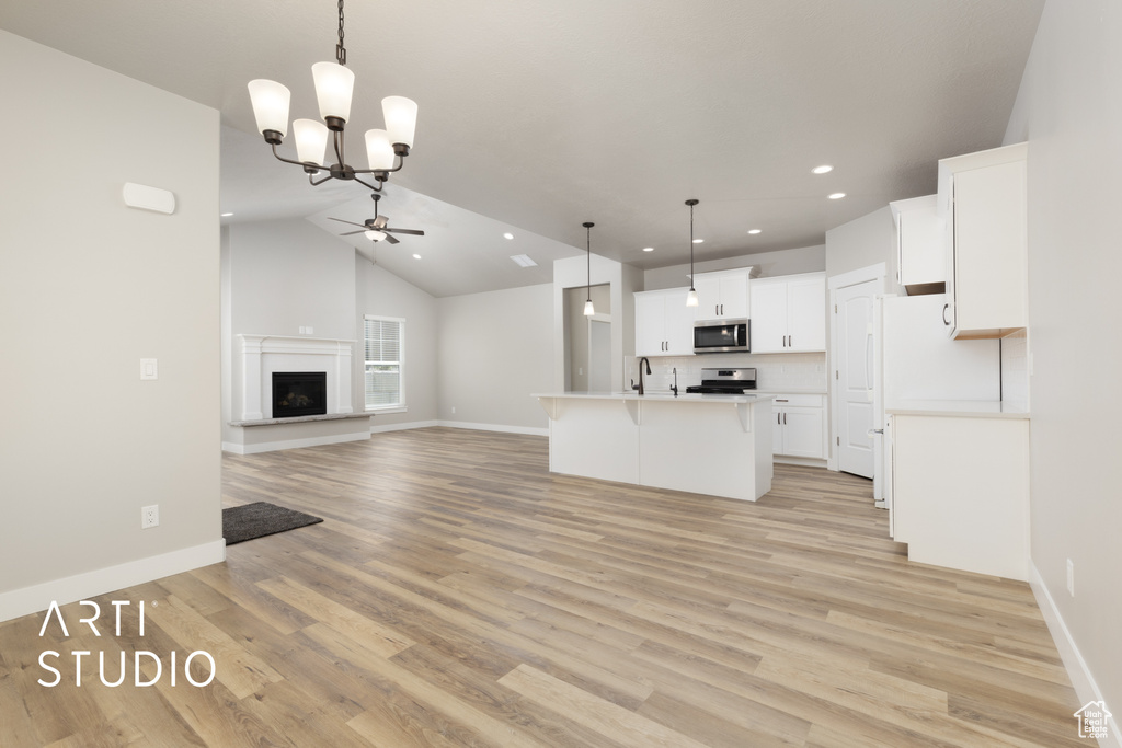 Kitchen featuring ceiling fan with notable chandelier, stainless steel appliances, open floor plan, light countertops, and recessed lighting