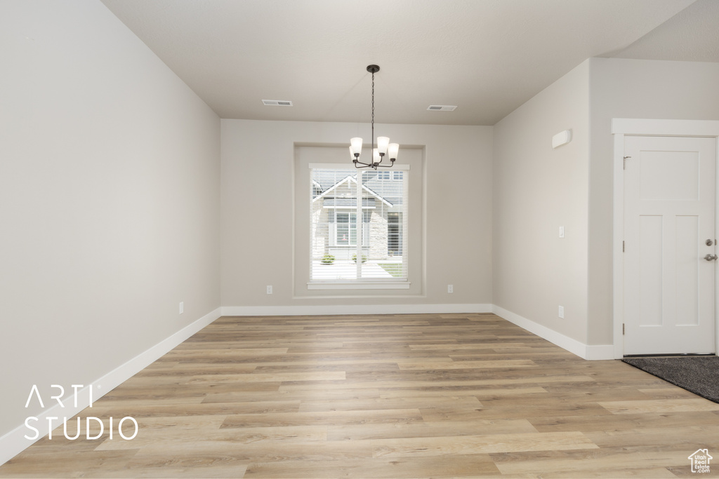 Unfurnished dining area featuring baseboards, a chandelier, and visible vents