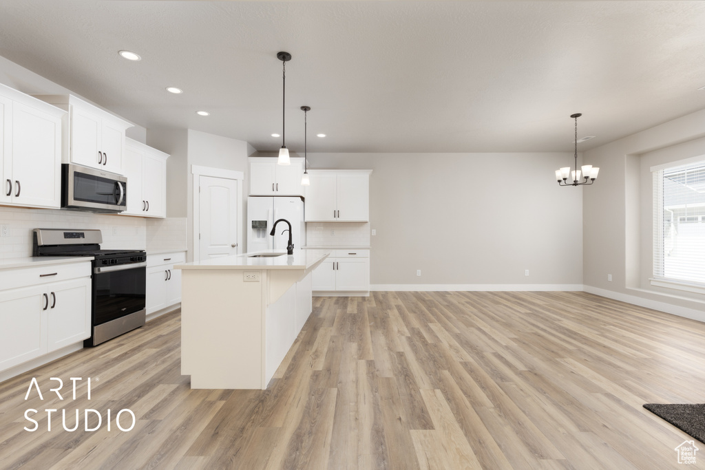Kitchen featuring light countertops, tasteful backsplash, appliances with stainless steel finishes, and a sink
