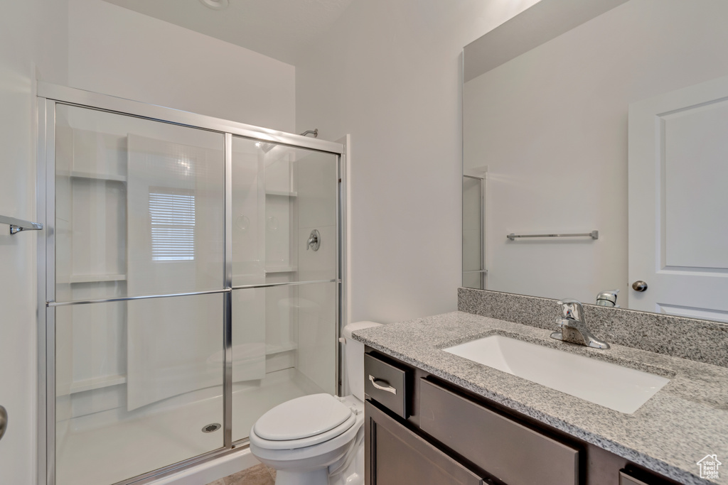 Full bathroom with a stall shower, vanity, and toilet
