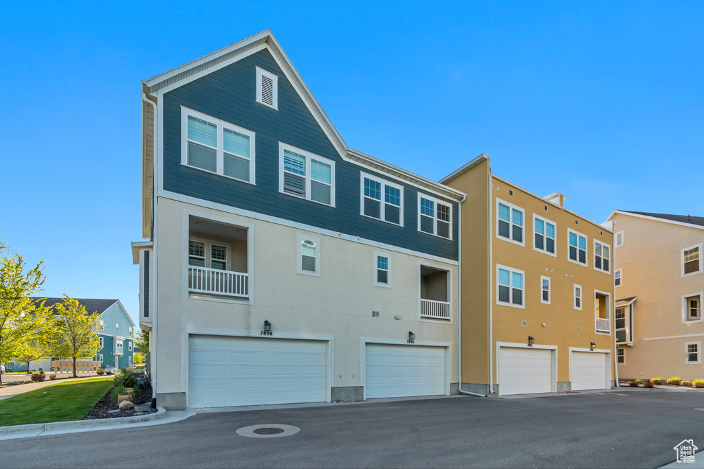 View of building exterior with driveway and a garage