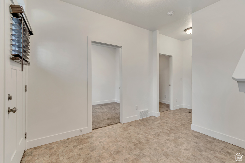 Spare room featuring baseboards, light floors, and visible vents