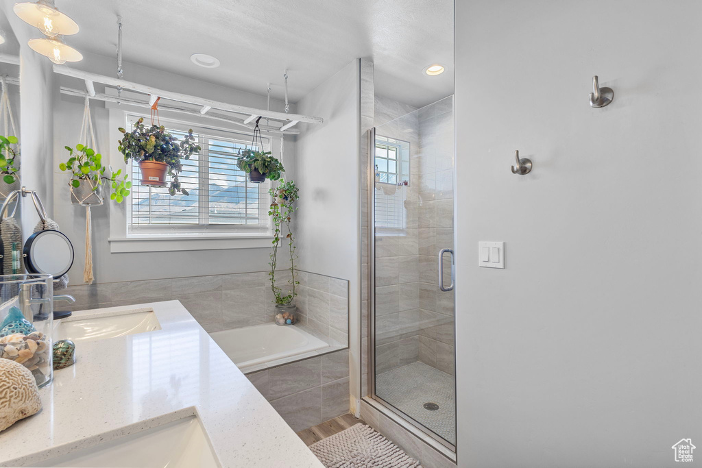 Bathroom featuring a bath, vanity, a stall shower, and recessed lighting