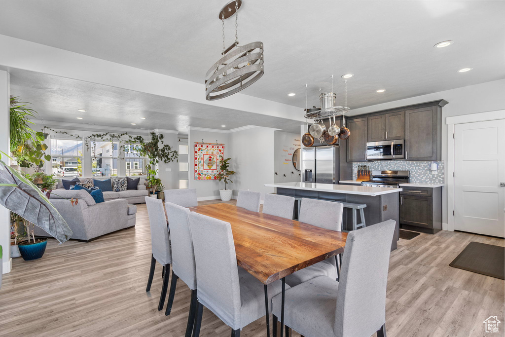 Dining space with light wood finished floors and recessed lighting