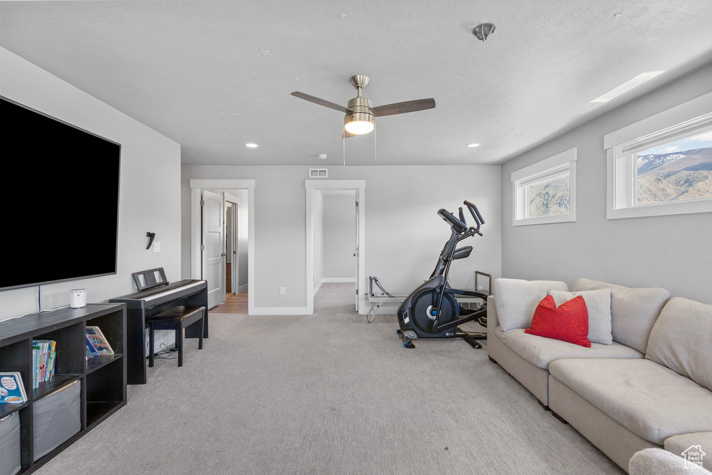 Interior space featuring light colored carpet, baseboards, ceiling fan, and recessed lighting