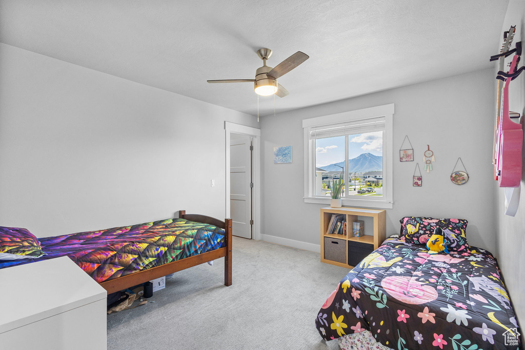 Carpeted bedroom with baseboards and a ceiling fan
