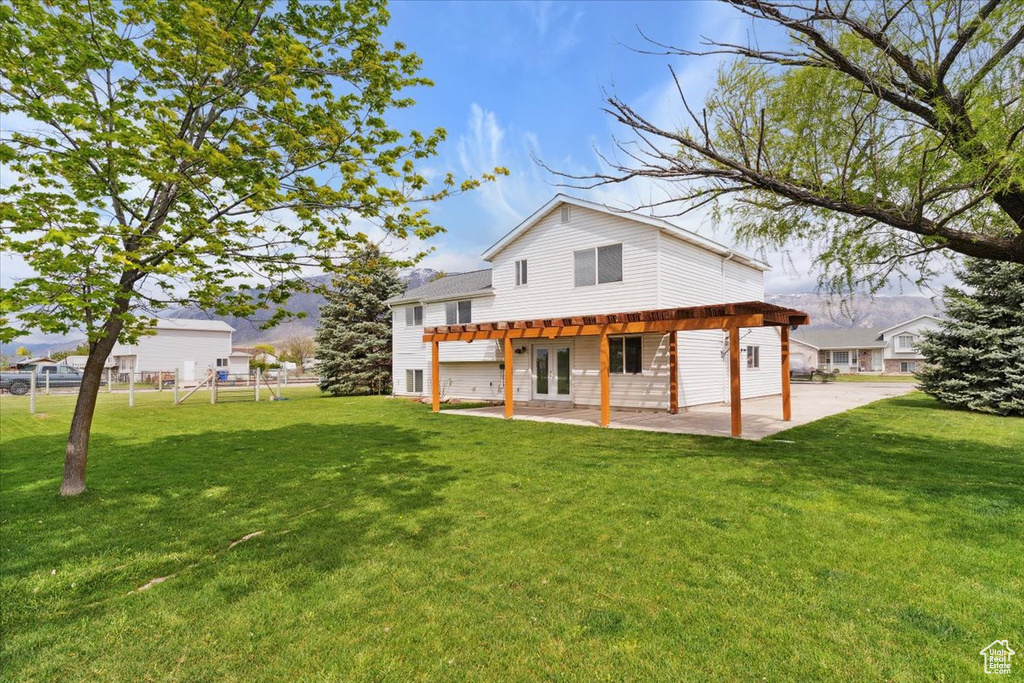 Back of house featuring a playground, a patio area, french doors, and a lawn