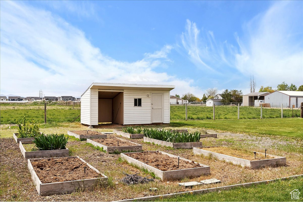 View of shed featuring fence and a garden