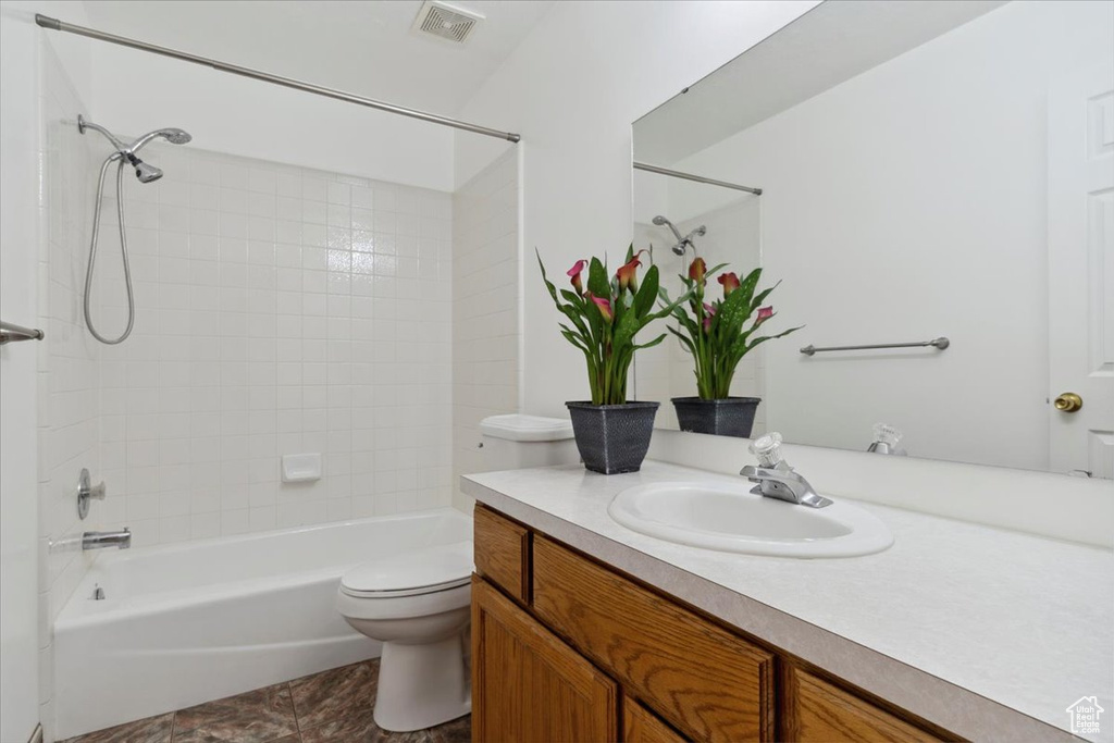 Full bathroom featuring toilet, shower / tub combination, visible vents, tile patterned flooring, and vanity