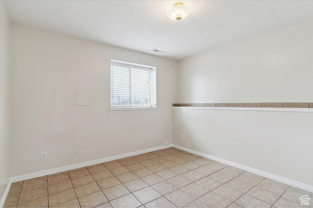 Spare room with baseboards, visible vents, and light tile patterned flooring