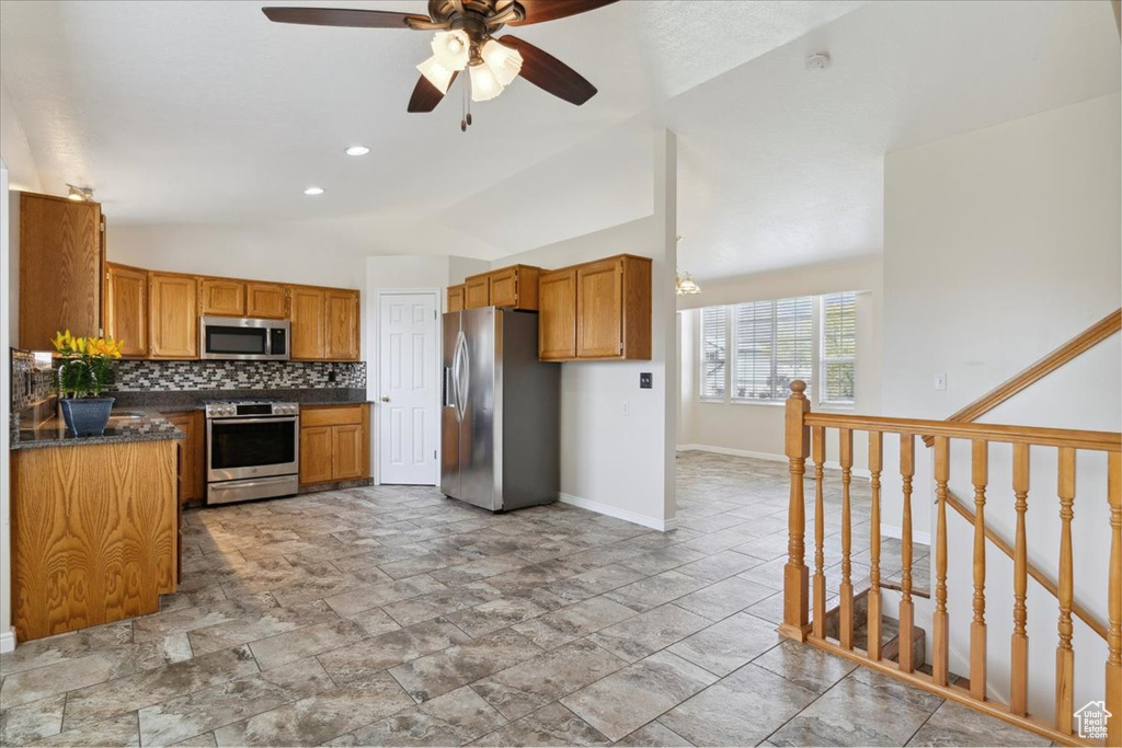 Kitchen with stainless steel appliances, tasteful backsplash, a ceiling fan, baseboards, and dark countertops