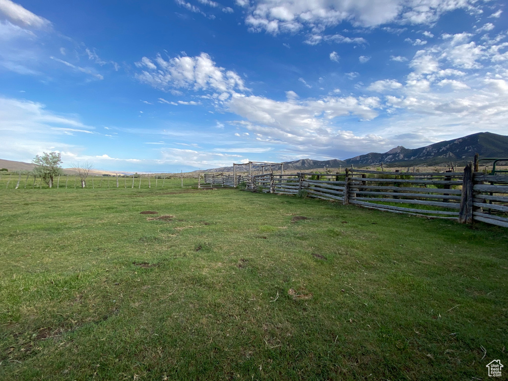 View of yard featuring fence, a rural view, and a mountain view