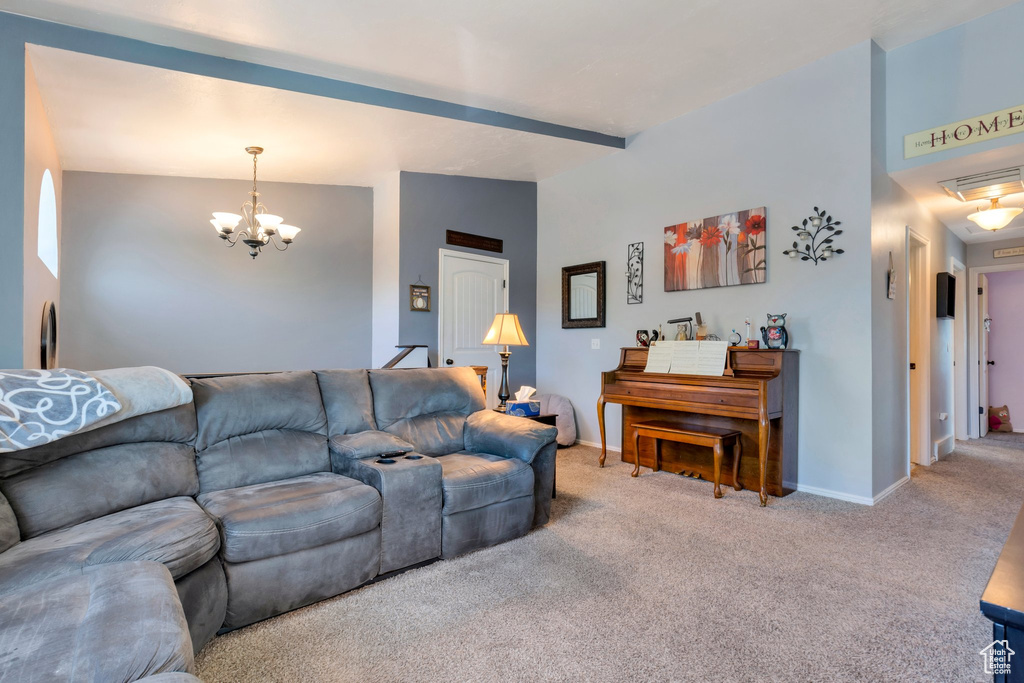Living room featuring carpet flooring, a notable chandelier, baseboards, and visible vents