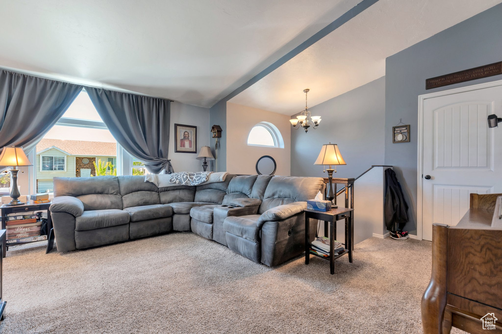 Living room featuring vaulted ceiling, a chandelier, and carpet floors