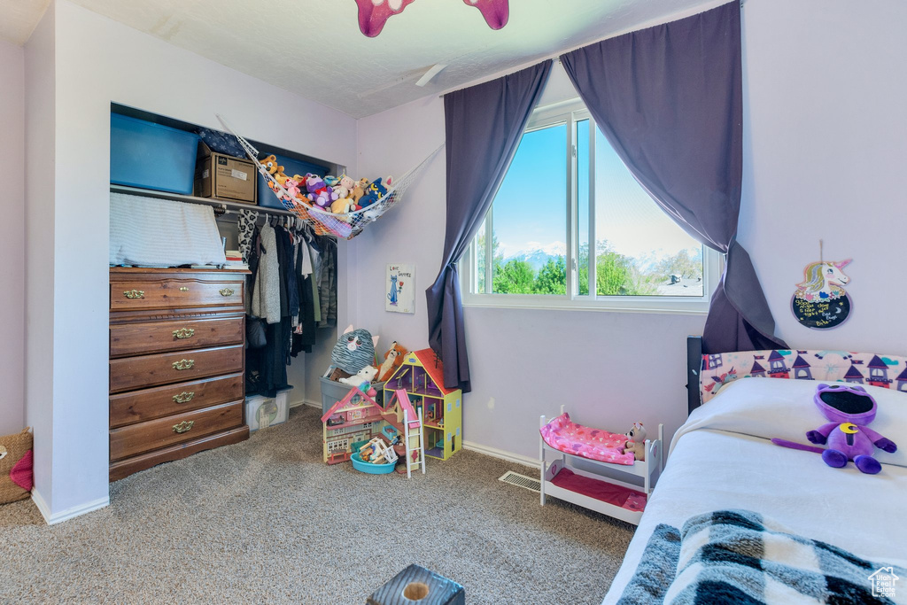 Carpeted bedroom featuring a closet and baseboards