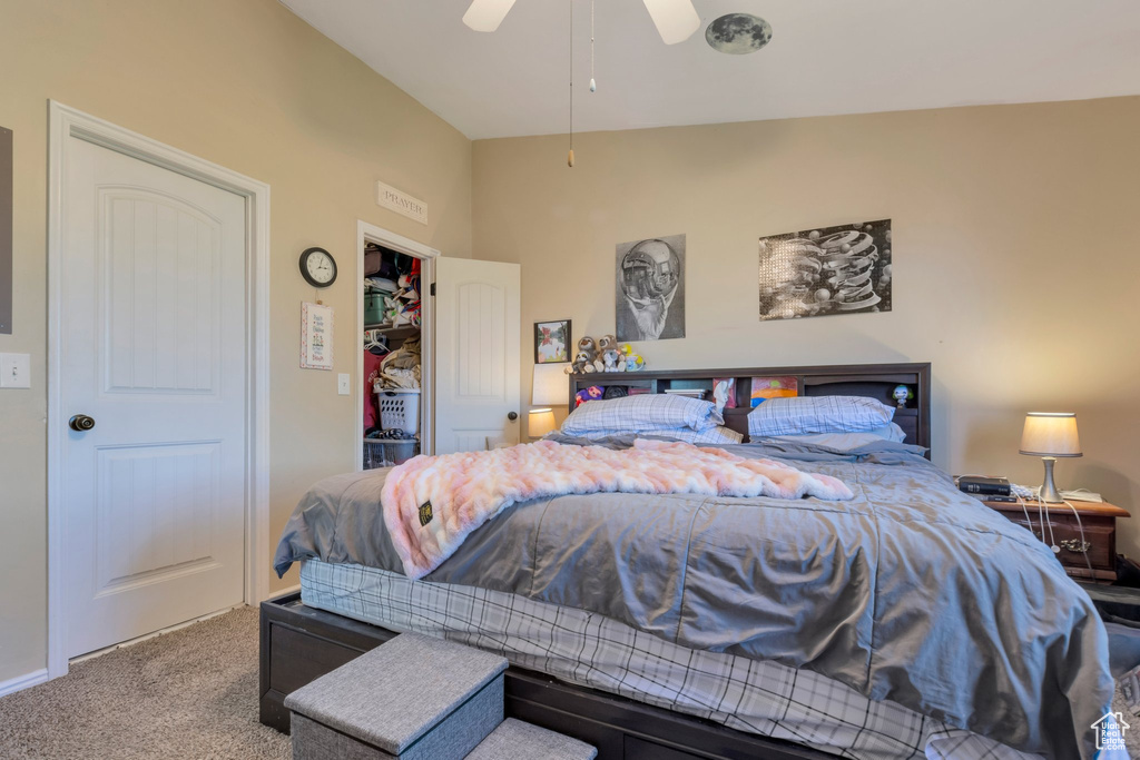 Carpeted bedroom with lofted ceiling and a ceiling fan