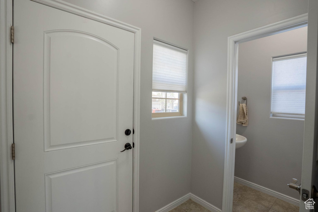 Entryway with light tile patterned floors and baseboards