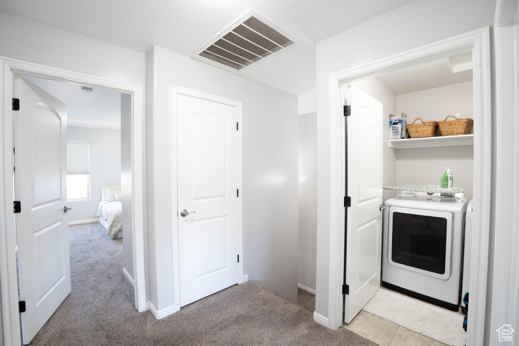 Washroom with laundry area, light carpet, washer / dryer, and visible vents