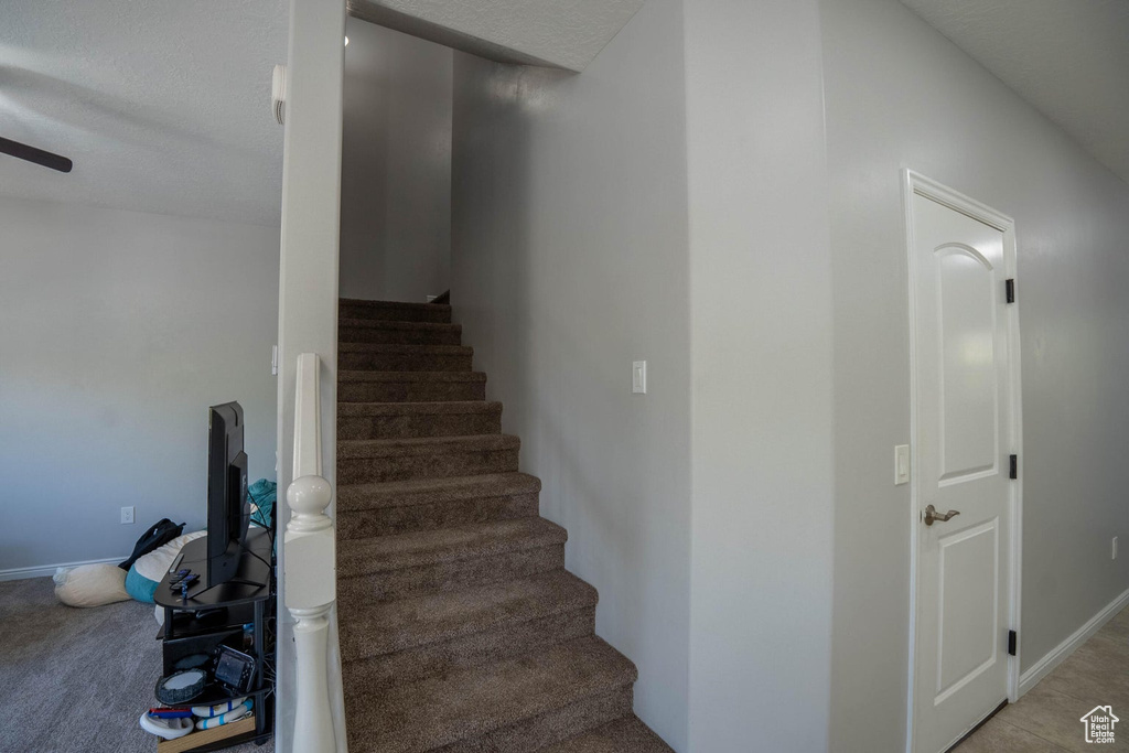 Stairs featuring baseboards and ceiling fan