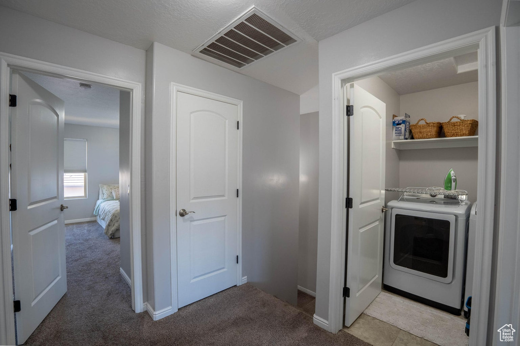 Washroom featuring washer / clothes dryer, light carpet, baseboards, and visible vents