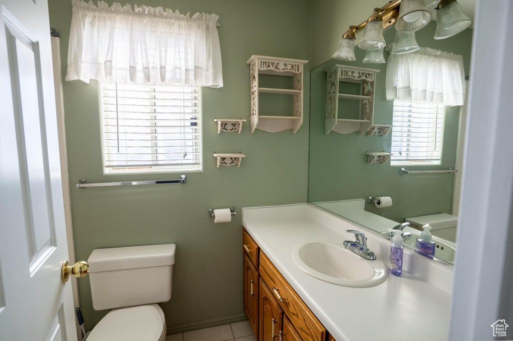 Bathroom with toilet, tile patterned flooring, and vanity