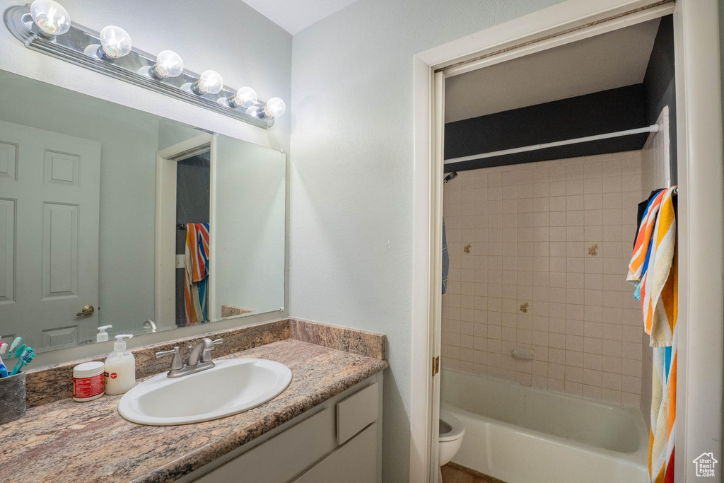 Bathroom featuring vanity, toilet, and bathing tub / shower combination