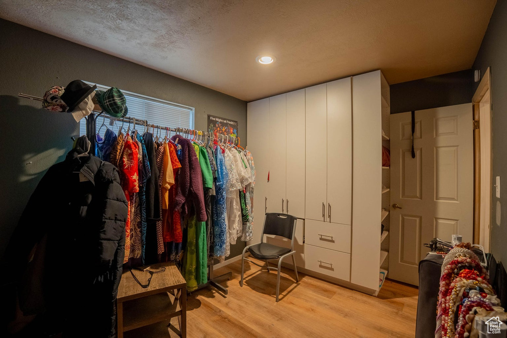 Walk in closet with light wood-style flooring