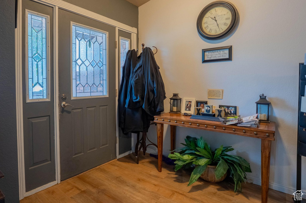 Foyer entrance with wood finished floors and baseboards