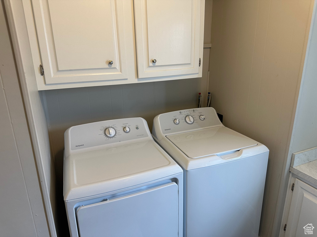 Laundry room featuring independent washer and dryer and cabinet space