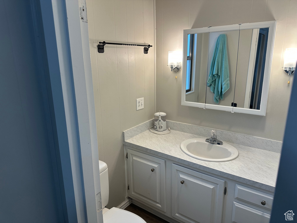 Half bathroom with vanity and toilet