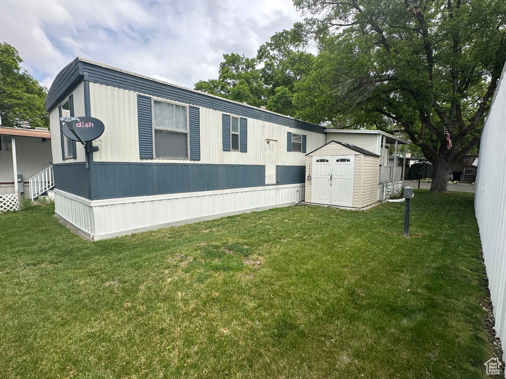 Exterior space featuring a front lawn, an outbuilding, and a shed