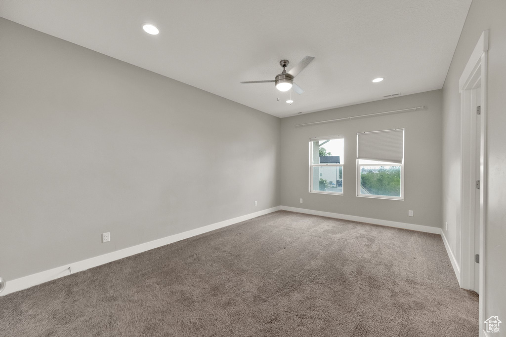 Carpeted spare room featuring baseboards, a ceiling fan, and recessed lighting