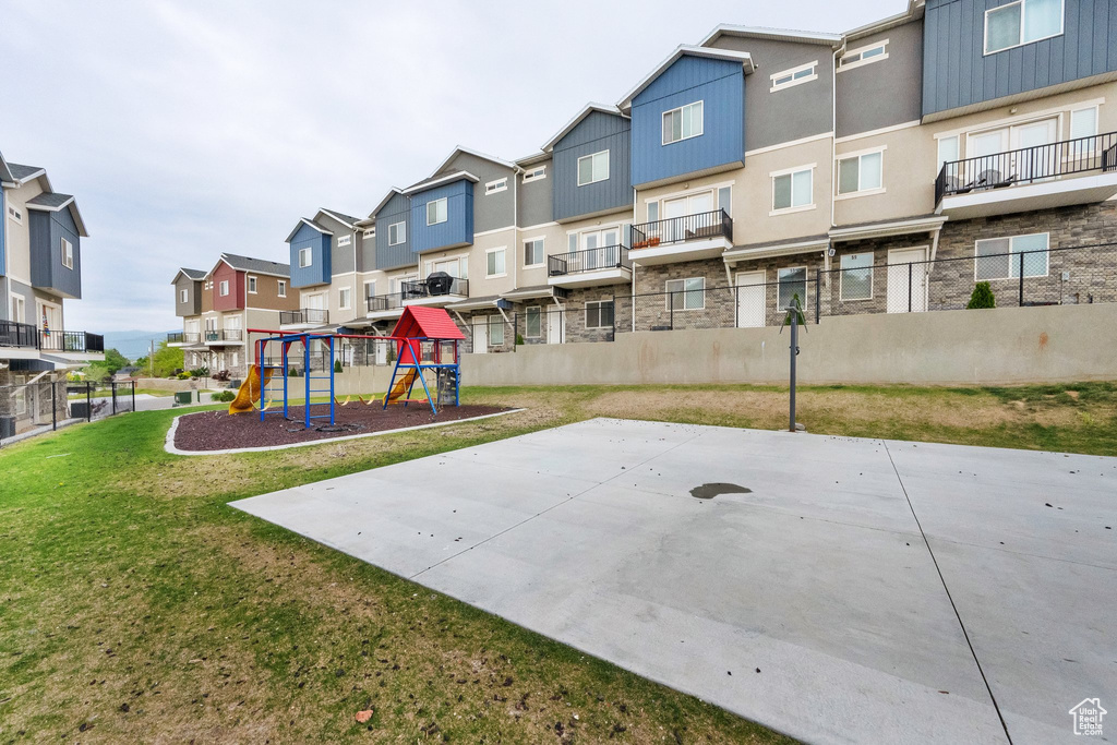 Exterior space featuring playground community, fence, a residential view, and a lawn