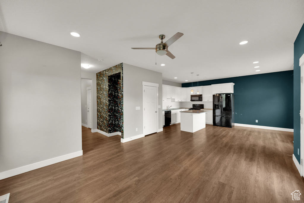 Unfurnished living room featuring dark wood finished floors, baseboards, a ceiling fan, and recessed lighting