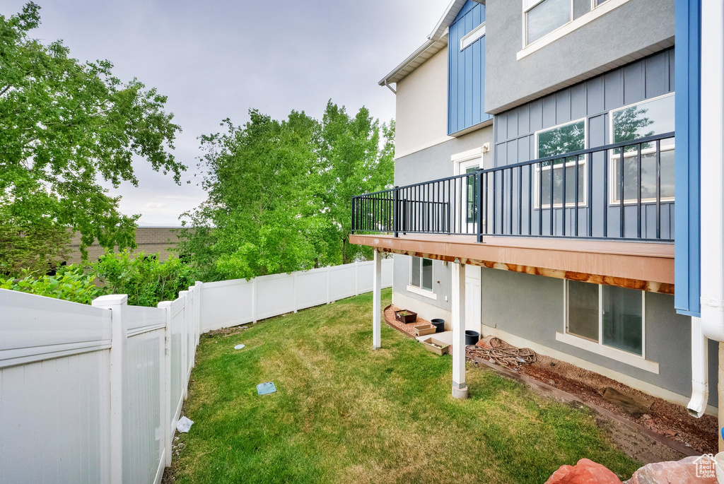 View of yard with a fenced backyard and a balcony