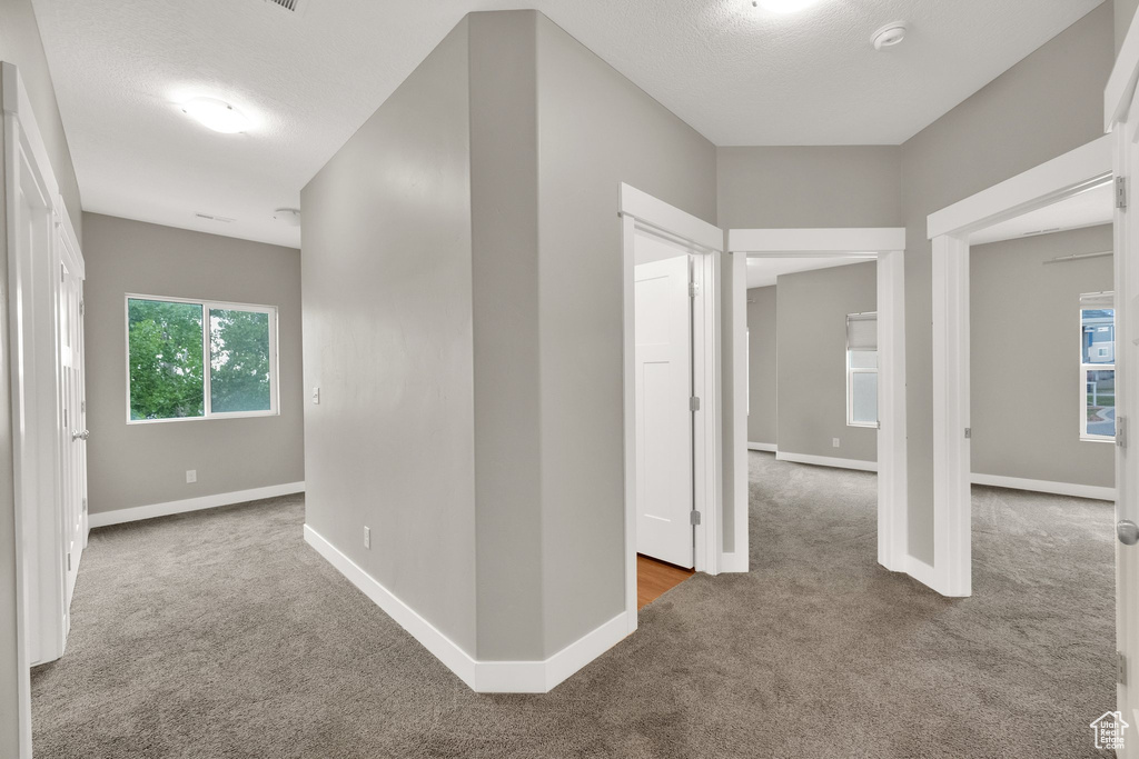 Corridor featuring carpet flooring and baseboards