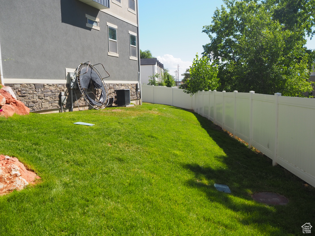 View of yard featuring fence and central AC