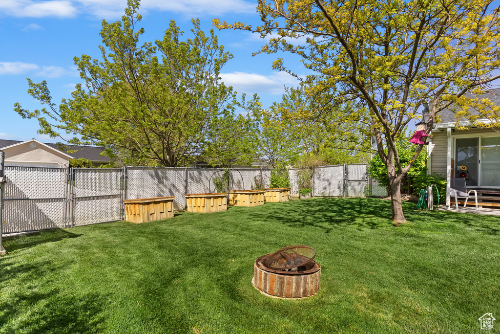 View of yard with a fire pit and a fenced backyard
