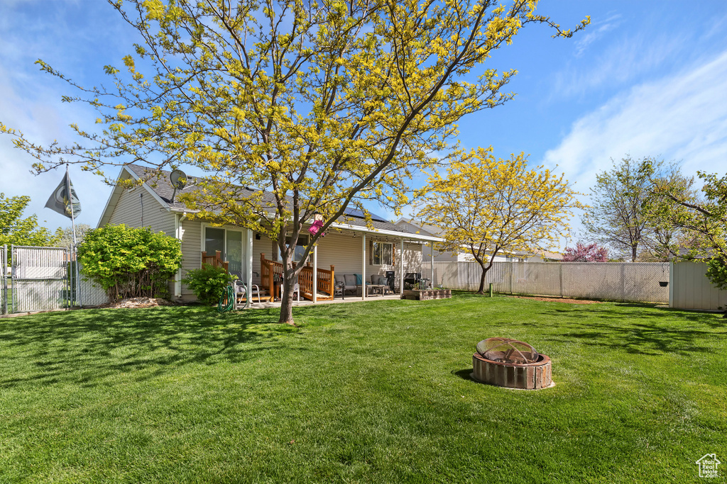 View of yard featuring a fire pit, a patio, and a fenced backyard