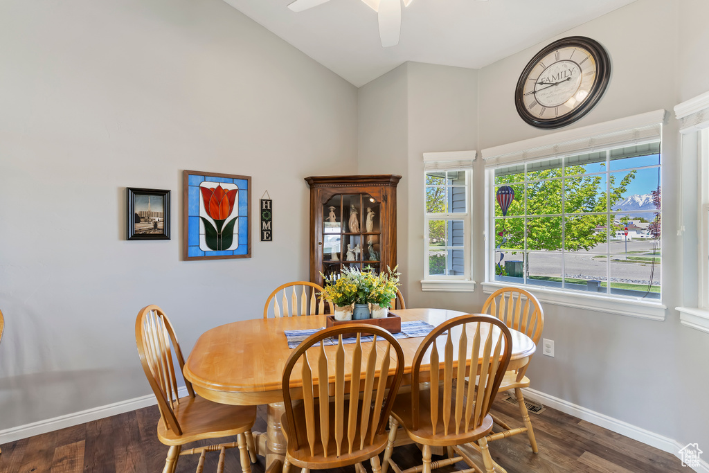 Dining area with high vaulted ceiling, baseboards, a ceiling fan, and wood finished floors
