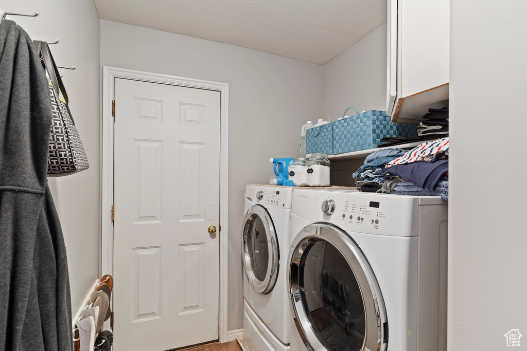 Laundry area featuring washer and clothes dryer and cabinet space