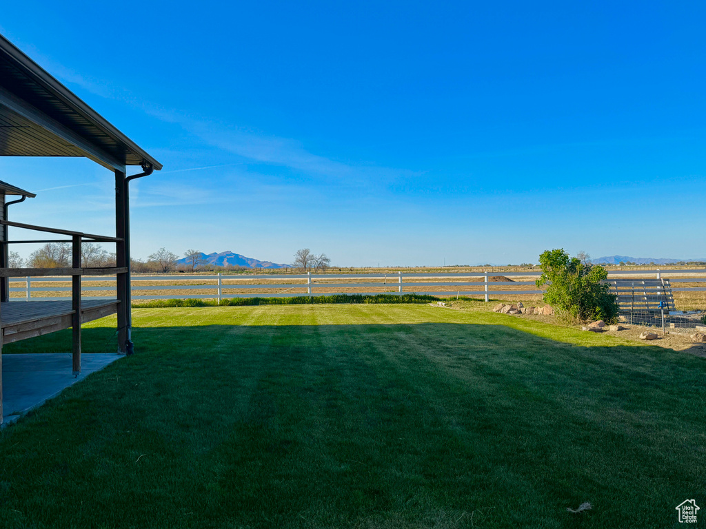 View of yard with a mountain view, a rural view, and fence