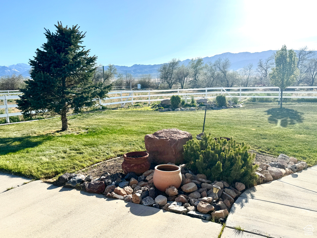 View of yard featuring fence, a rural view, and a mountain view