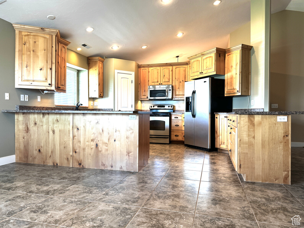 Kitchen with a peninsula, stainless steel appliances, visible vents, and recessed lighting
