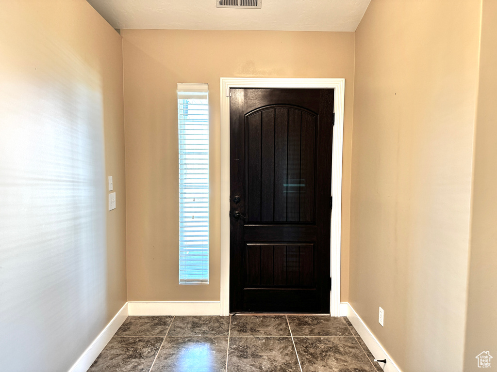 Foyer with baseboards and visible vents