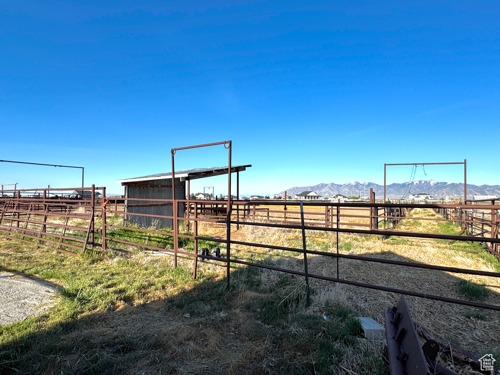 View of yard with a mountain view, a rural view, an outdoor structure, and an exterior structure