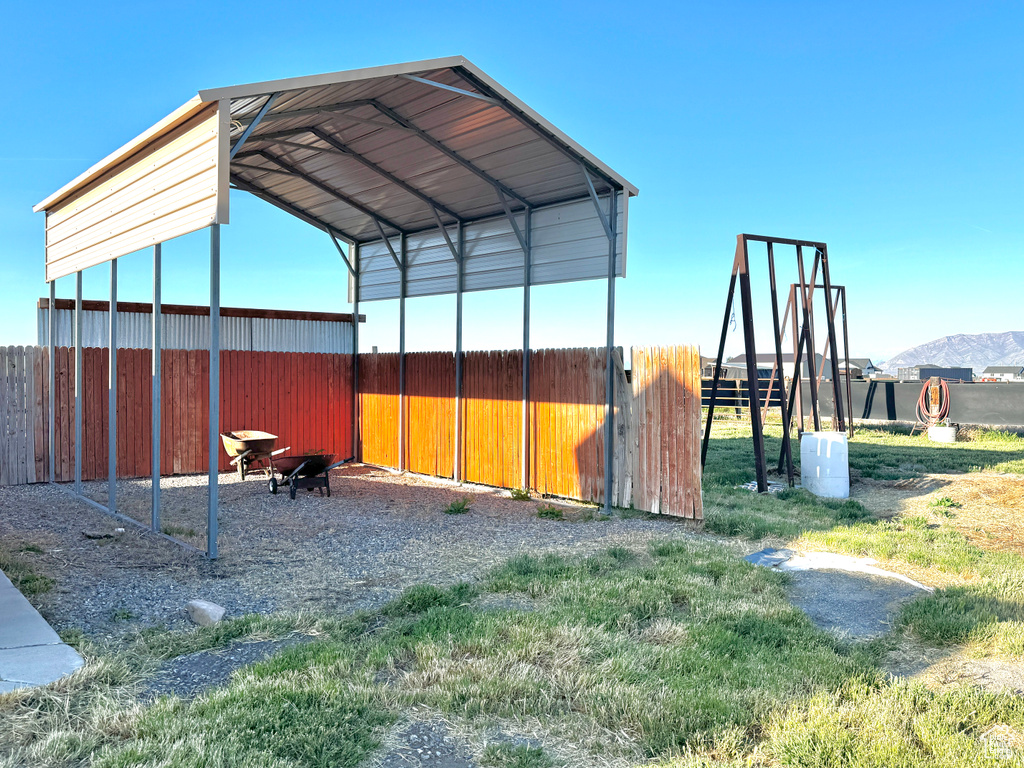 View of outbuilding featuring a detached carport and fence