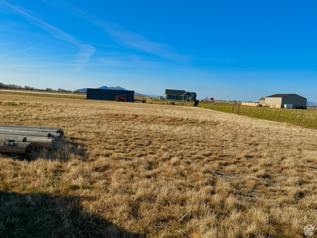 View of yard with a rural view and fence
